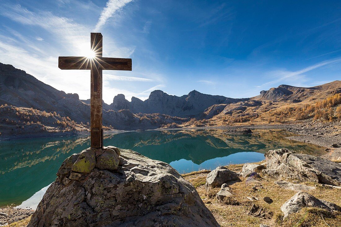 Frankreich, Alpes-de-Haute-Provence, Parc National du Mercantour (Nationalpark Mercantour), Haut Verdon, Holzkreuz am See Allos (2 228 m) im Herbst, vor dem Hintergrund beeindruckender Sandsteintürme von Annot