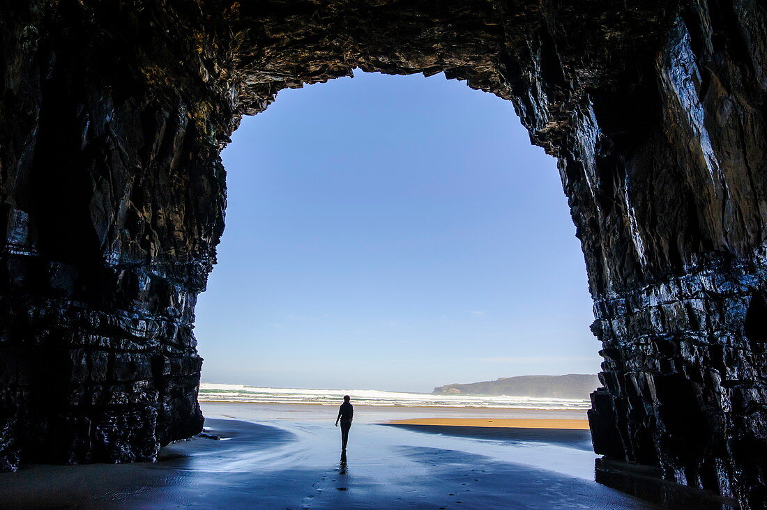 Frau steht in den gigantischen Höhlen der Kathedrale, The Catlins, Südinsel, Neuseeland, Pazifik