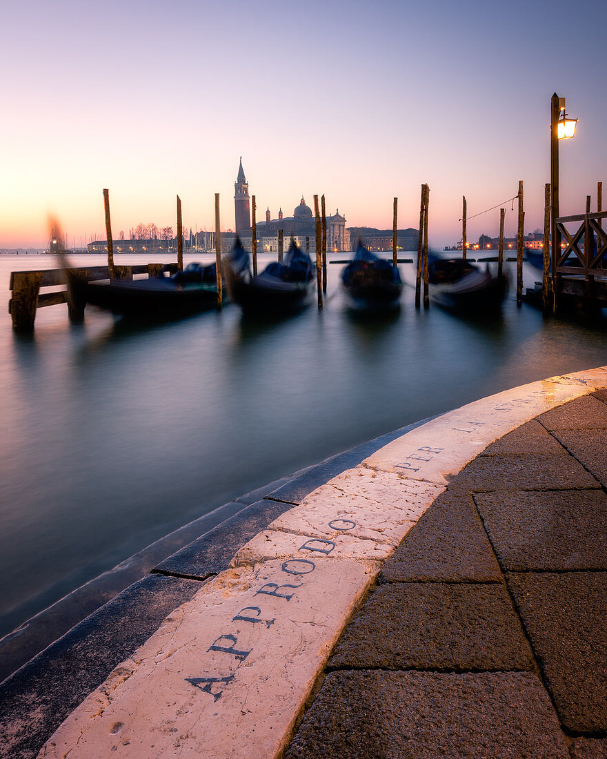 Langzeitbelichtung von Gondeln durch San Giorgio Maggiore bei Sonnenuntergang in Venedig, Italien, Europa