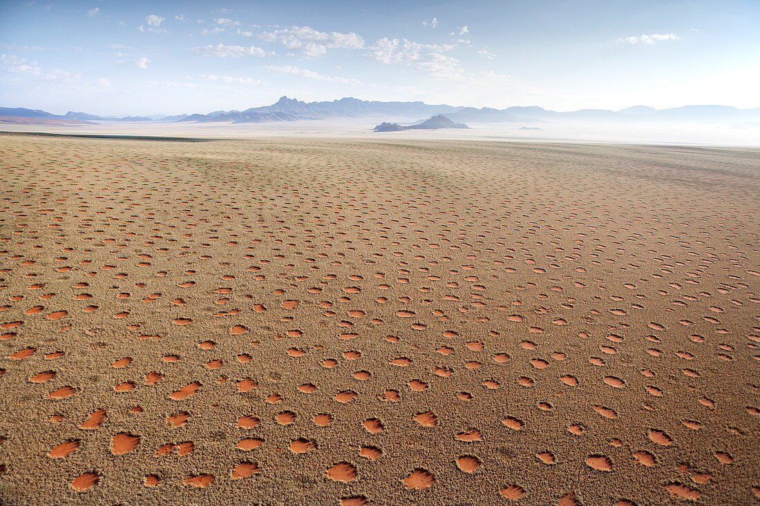 Aerial view from hot air balloon over magnificent desert landscape of sand dunes, mountains and Fairy Circles, Namib Rand game reserve Namib Naukluft Park, Namibia, Africa