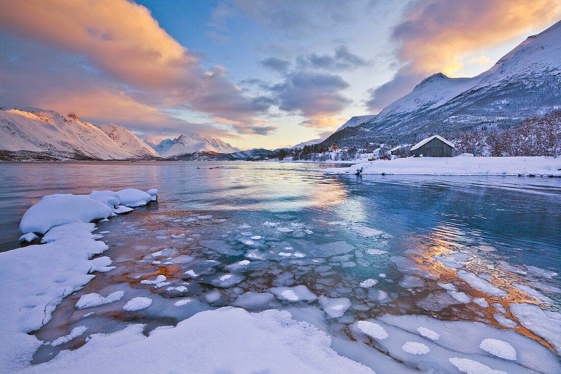 Looking across the frozen sea of Ullsfjord from Sjursnes, towards the Southern Lyngen Alps, at sunset, Troms, Norway, Scandinavia, Europe