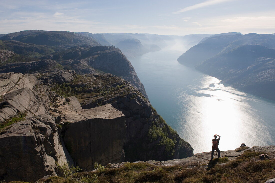 Mann fotografiert den Fjord, Preikestolen (Kanzelfelsen), Lysefjord, Norwegen, Skandinavien, Europa