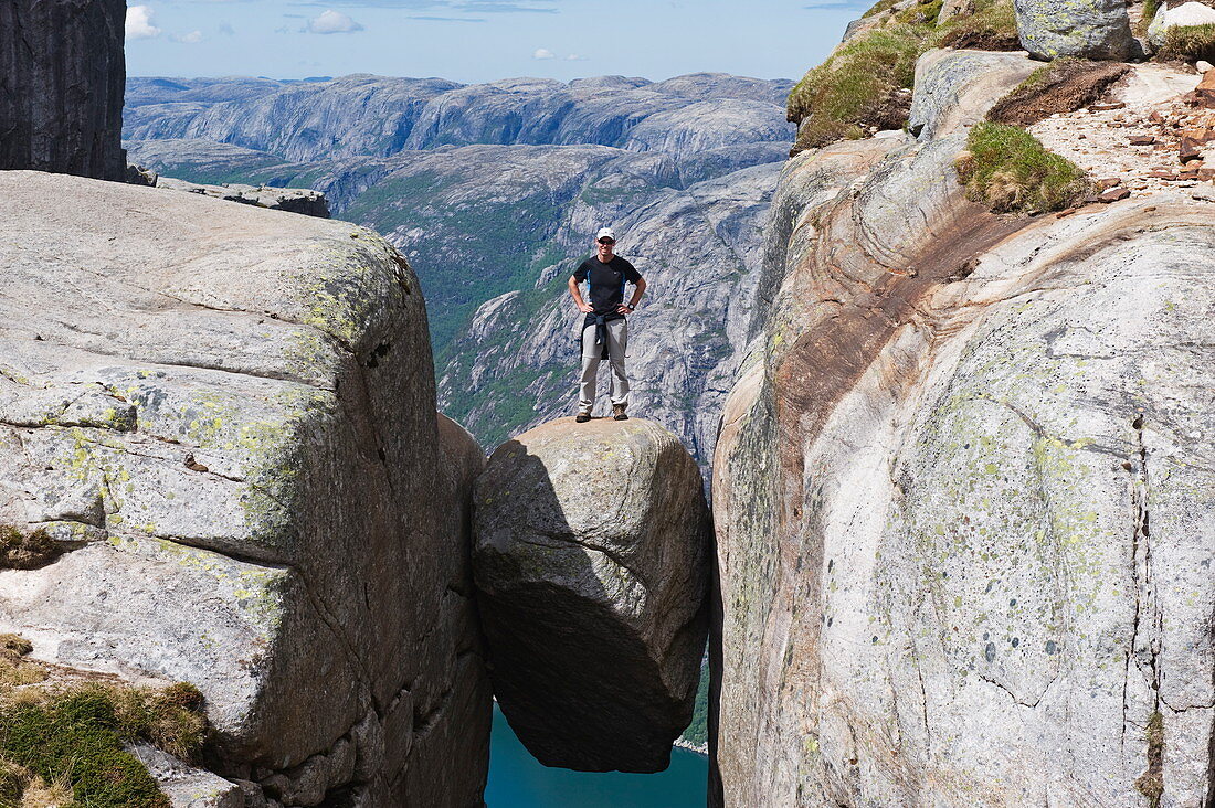 Mann steht auf einem Felsen, Kjeragbolten, Kerag Chockstone Boulder, Lyseboten, Lysefjord, Norwegen, Skandinavien, Europa