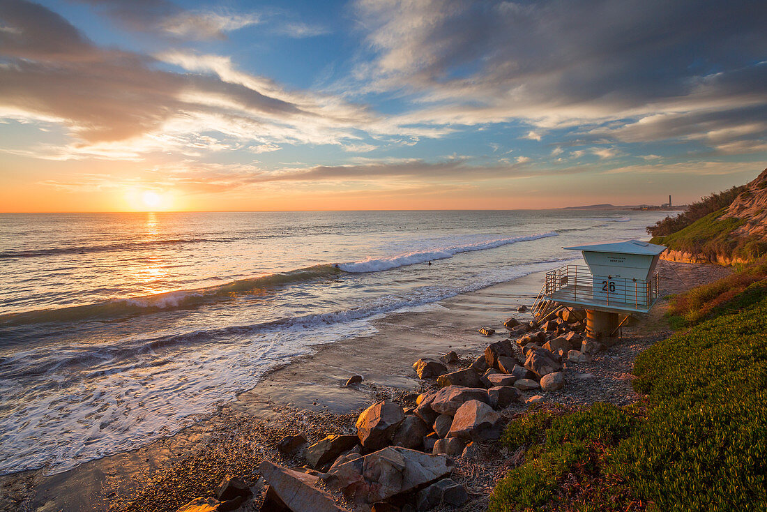 Sonnenuntergang am Strand an der Westküste Kaliforniens mit Rettungsschwimmer-Turm\n