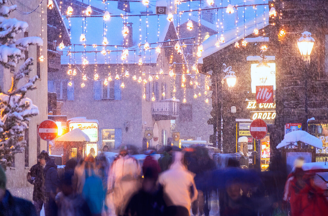 Busy street with tourists during snowfall, Livigno, Valtellina, Lombardy, Italy, Europe