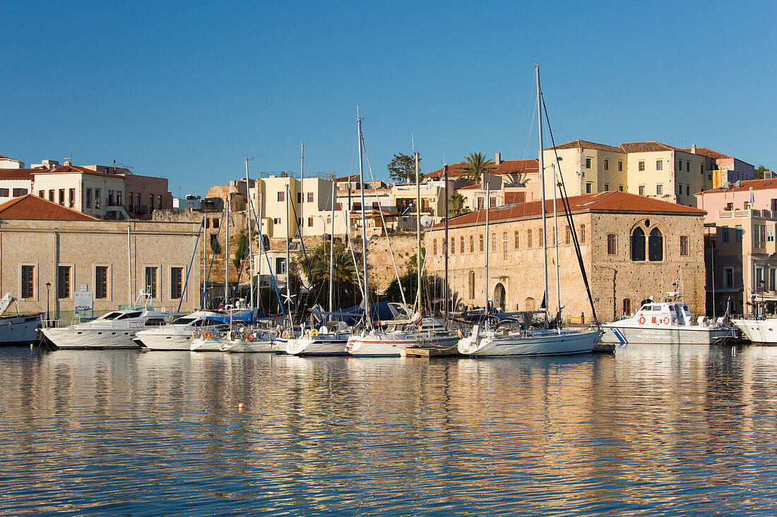 Blick über den alten Hafen, am frühen Morgen, im Wasser gespiegelte Kaigebäude, Hania (Chania), Kreta, Griechische Inseln, Griechenland, Europa