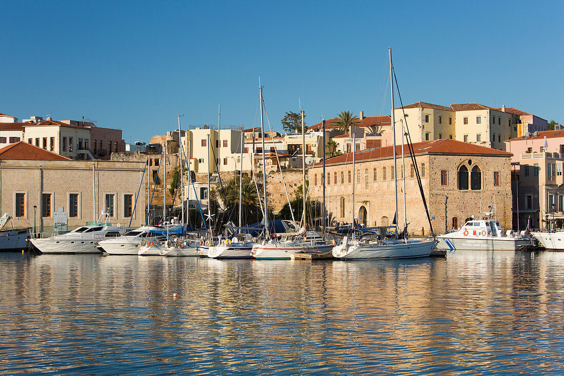 View across the Old Harbour, early morning, quayside buildings reflected in water, Hania (Chania), Crete, Greek Islands, Greece, Europe