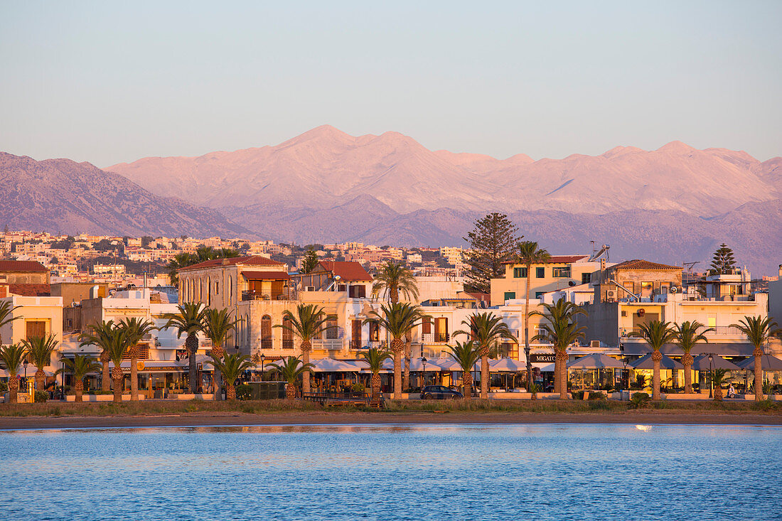 View to the waterfront and distant peaks of the Lefka Ori, sunrise, Rethymno (Rethymnon), Crete, Greek Islands, Greece, Europe