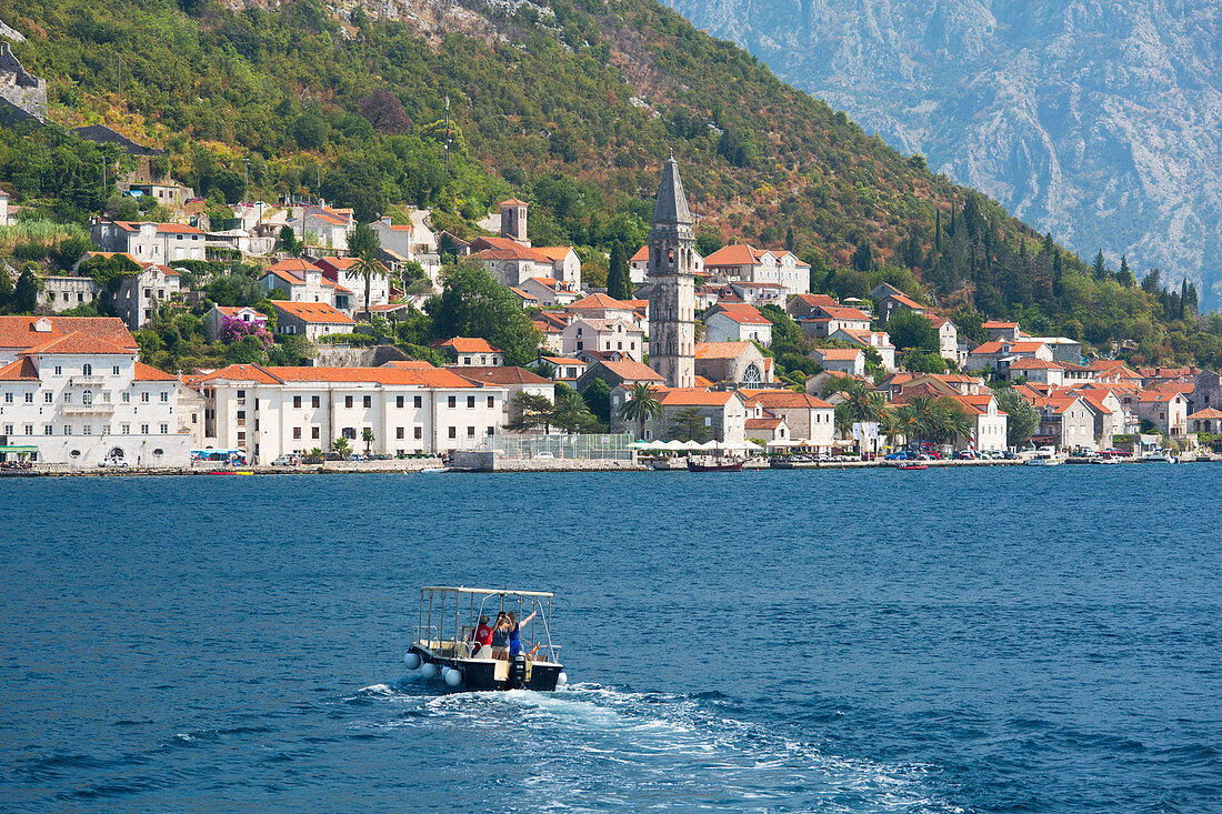 Kleines Boot in Richtung der Uferpromenade über die Bucht von Kotor, Perast, Kotor, UNESCO-Weltkulturerbe, Montenegro, Europa