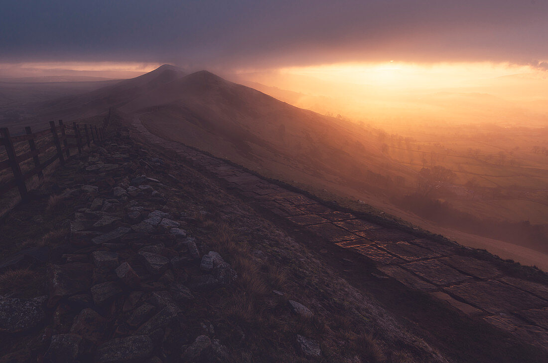 Der Weg auf Mam Tor führt in einen nebligen Sonnenaufgang, Peak District, Derbyshire, England, Großbritannien, Europa