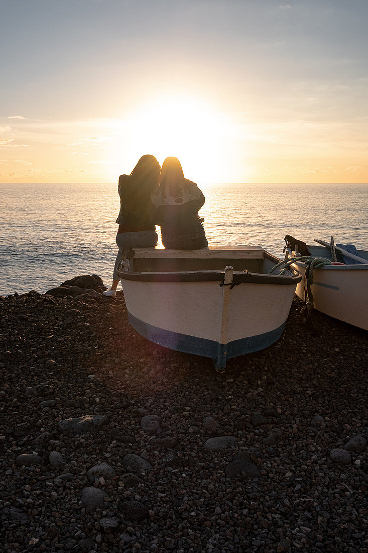 Zwei Frauen sitzen auf einem Boot und blicken auf den Atlantik, El Remo, La Palma, Kanarische Inseln, Spanien, Europa