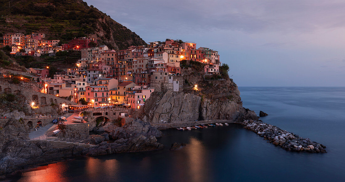 Bay in Cinque Terre with village Manarola in the evening with lights, Italy