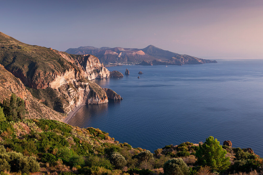 Küste von Lipari mit Blick auf Vulkaninsel Vulcano im Sonnenuntergang, Sizilien, Italien