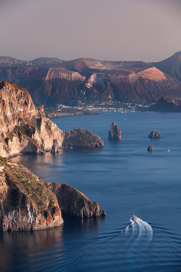 Küste von Lipari mit Blick auf Vulkaninsel Vulcano im Sonnenuntergang, Sizilien Italien\n