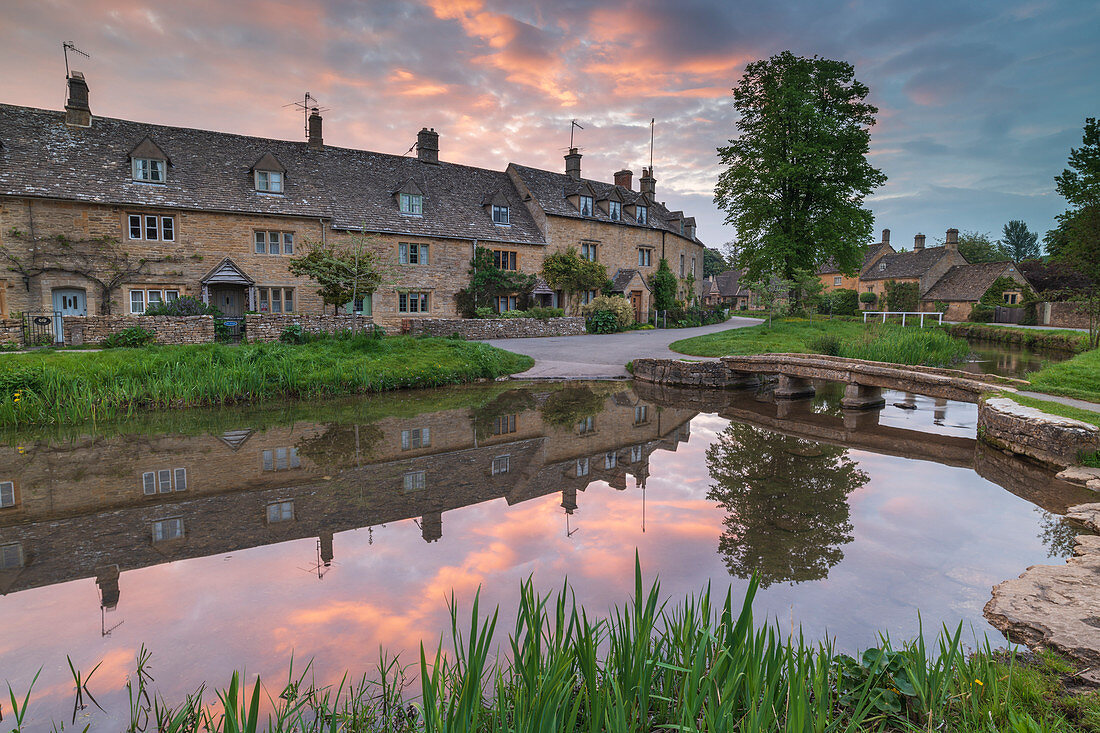 Colourful sunrise above the pretty village of Lower Slaughter in the Cotswolds, Gloucestershire, England, United Kingdom, Europe
