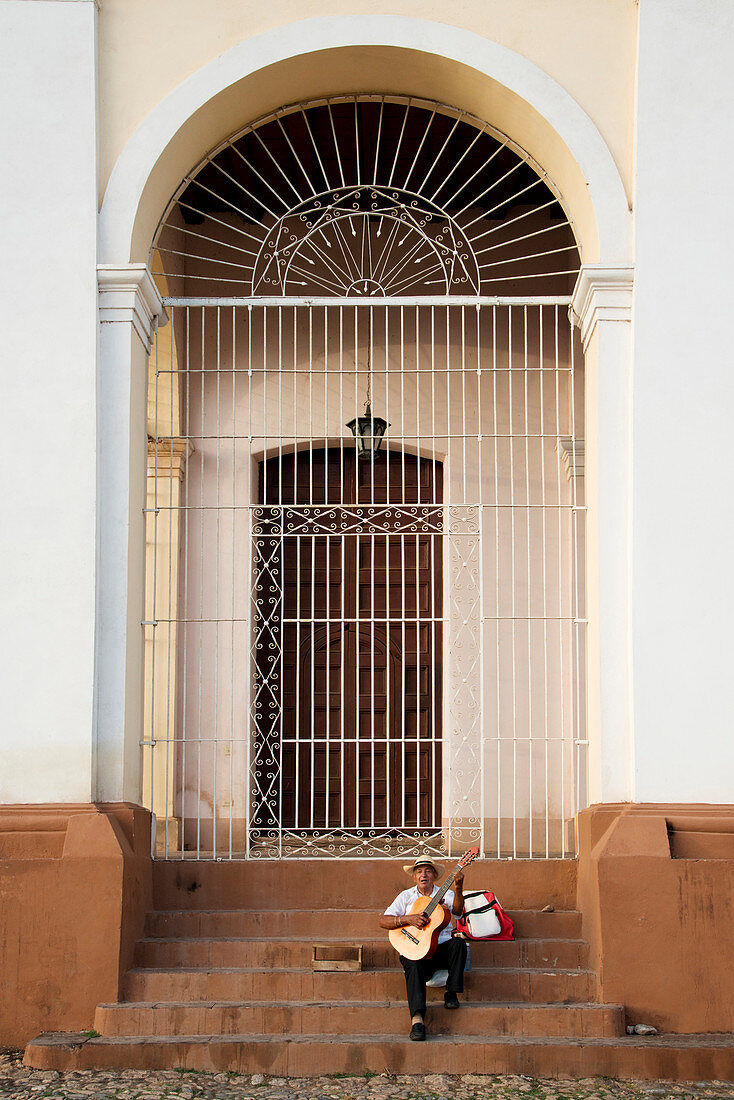 Man performing with his guitar on the steps of a church in Plaza Mayor, Trinidad, UNESCO World Heritage Site, Cuba, West Indies, Caribbean, Central America