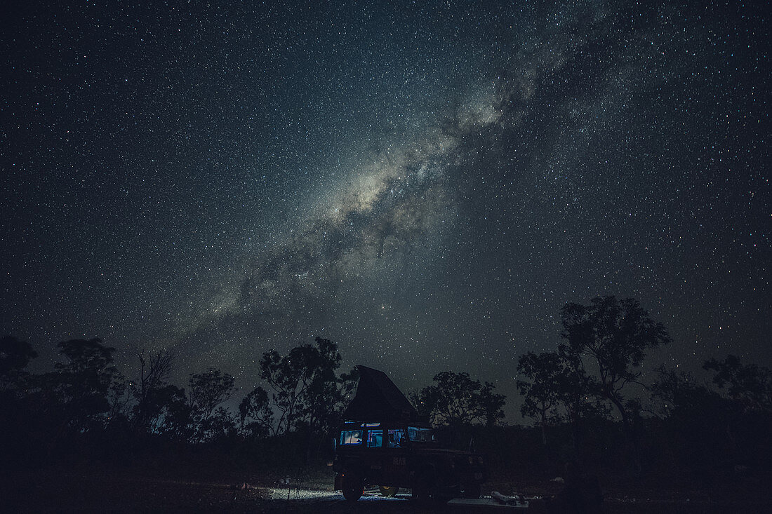 Landrover Defender SUV stands in the outback under a starry sky with the Milky Way, Darwin, Northern Territory, Australia, Oceania