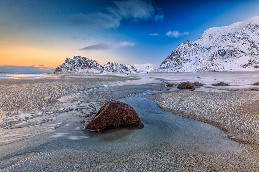 The first light of dawn illuminates the rocks shaped by the wind and the cold sea of Uttakleiv, Lofoten Islands, Arctic, Norway, Scandinavia, Europe