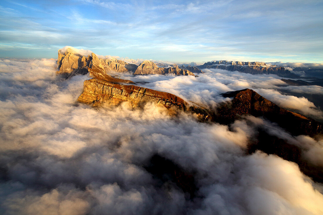 Luftaufnahme von Seceda von Odle, umgeben von Wolken bei Sonnenuntergang in den Dolomiten, Val Funes, Trentino-Südtirol Südtirol, Italien, Europa