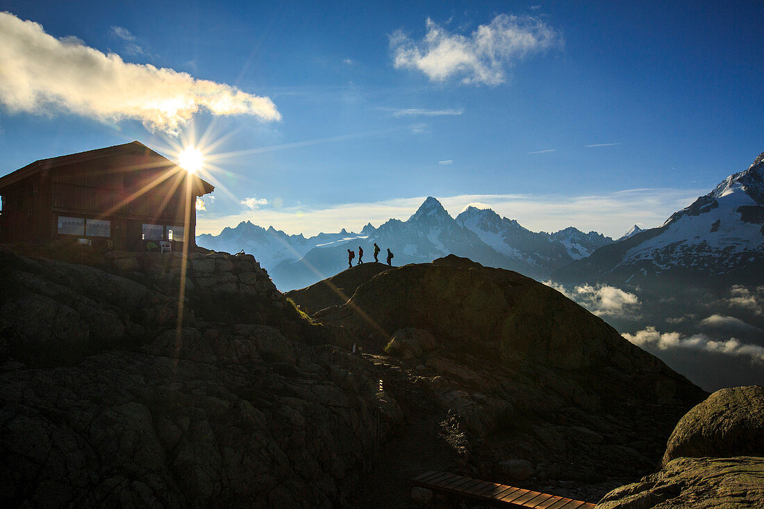 Wanderer gehen zur Berghütte am Lac de Cheserys mit der gerade aufgehenden Sonne, Chamonix, Haute Savoie, Französische Alpen, Frankreich, Europa