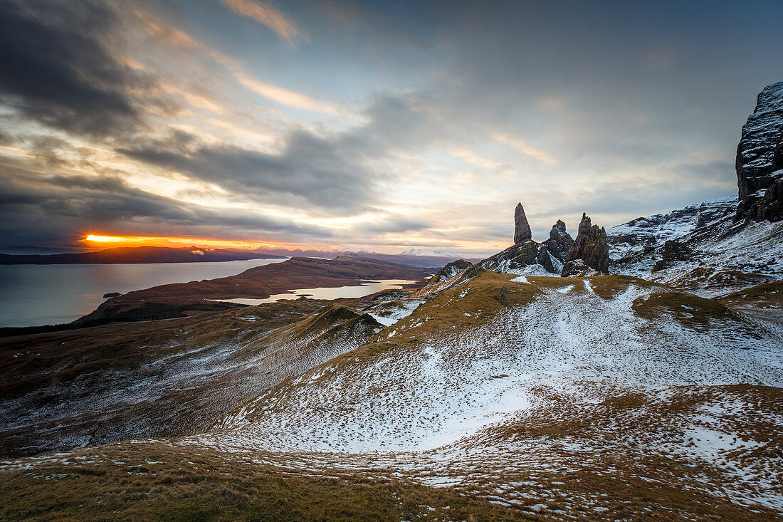 Der Sonnenaufgang durchbricht eine winterliche Landschaft auf dem Old Man of Storr, Isle of Skye, Innere Hebriden, Schottland, Vereinigtes Königreich, Europa
