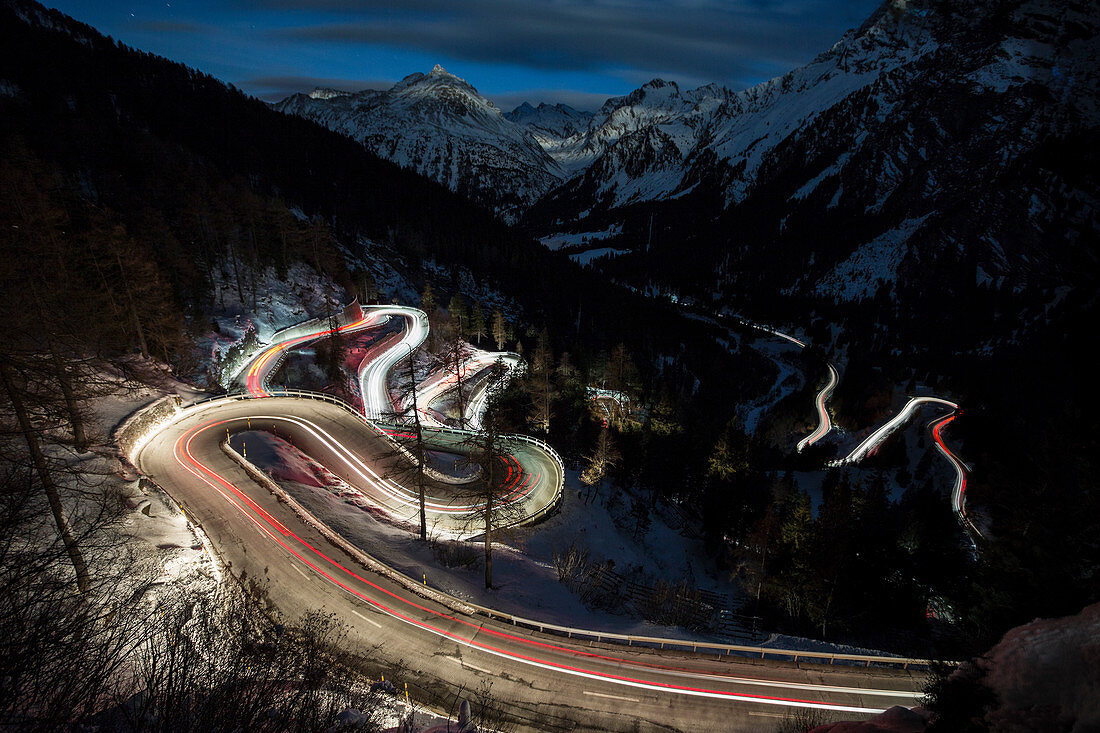 Autolichter auf der kurvigen Maloja-Passstraße bei Nacht, Maloja-Pass, Engadin, Provinz Graubunden, Schweiz, Europa