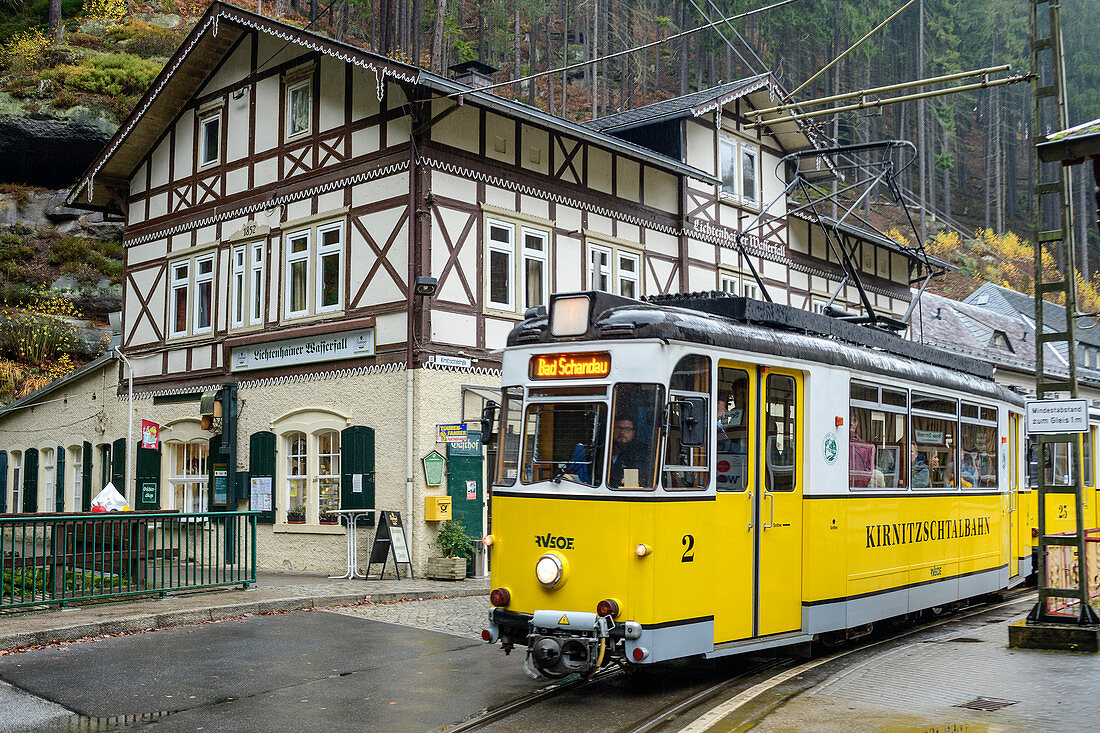 Historische Kirnitzschtalbahn fährt an Fachwerkhaus vorbei, Lichtenhain, Kirnitzschtal, Elbsandsteingebirge, Nationalpark Sächsische Schweiz, Sächsische Schweiz, Sachsen, Deutschland