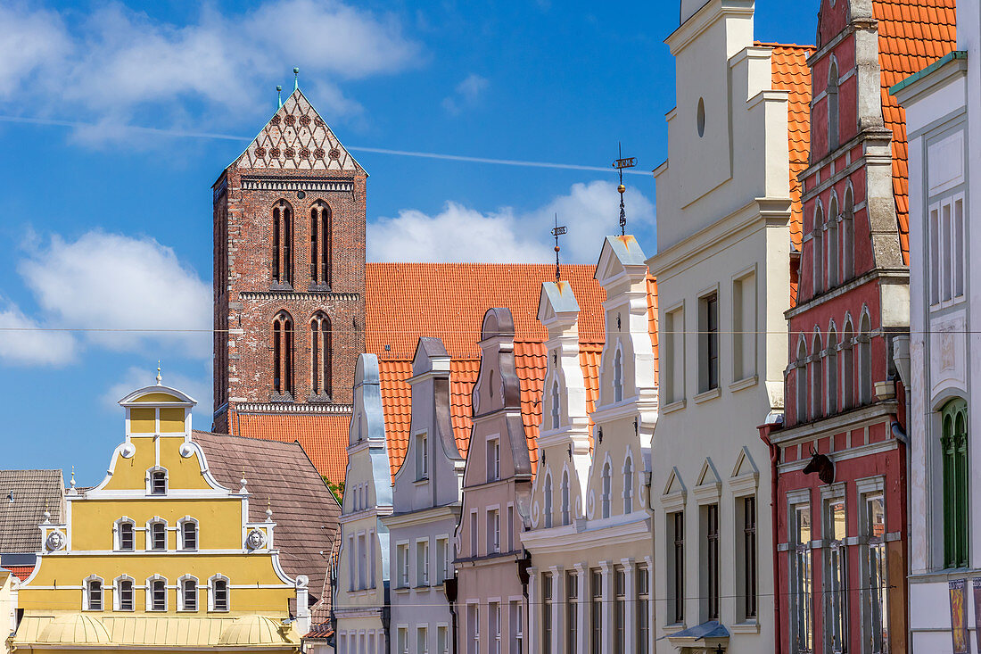 KrÃ¤merstraÃŸe, roofs, view from south toward north, at the end of the street yellow building of LÃ¶wenapotheke, and tower of St. Nikolai church, Wismar stadt, Mecklenburgâ€“Vorpommern, Germany.