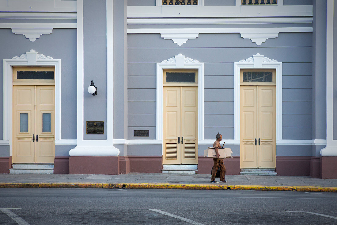Man in front of house facade of Palacio de Gobierno in Cienfuegos, Cuba