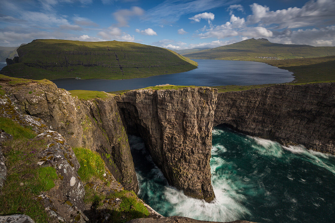 ABRUPT CLIFFS AND SORVAGSVATN LAKE ABOVE AN AGITATED SEA, LEITISVATN, VAGAR, FAROE ISLANDS, DENMARK