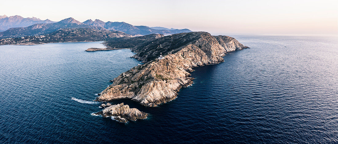 Motorboat under the lighthouse of the La Revellata peninsula, Calvi, Corsica, France.