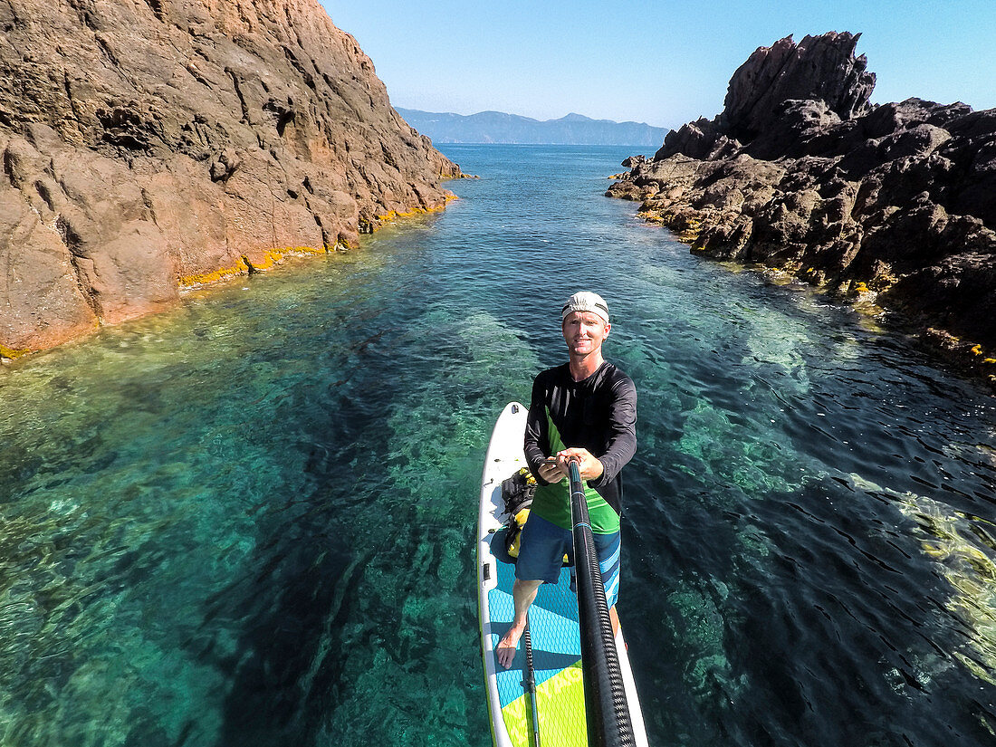 Stand-up paddlers in the Scandola Nature Reserve, Galeria, Calvi, Corsica, France