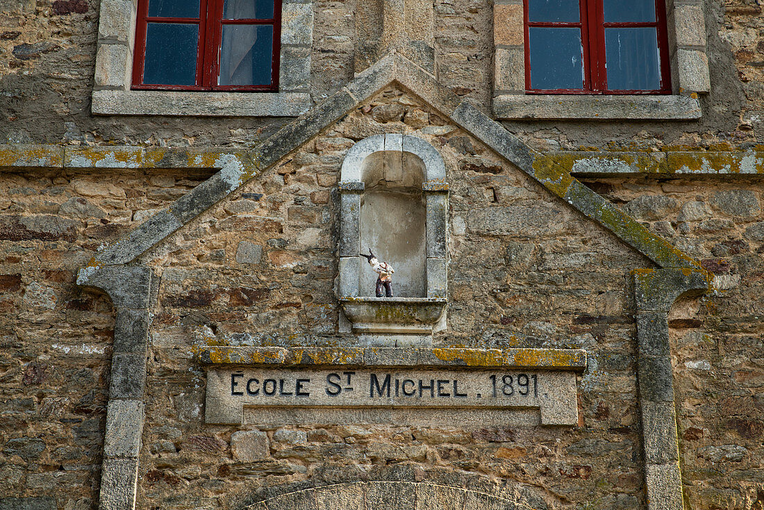 Portal of the Ecole St. Michel from 1891 with a small artistic figure of a boy with twin / slingshot, La Roche-Bernard, Vilaine, Morbihan department, Brittany, France, Europe