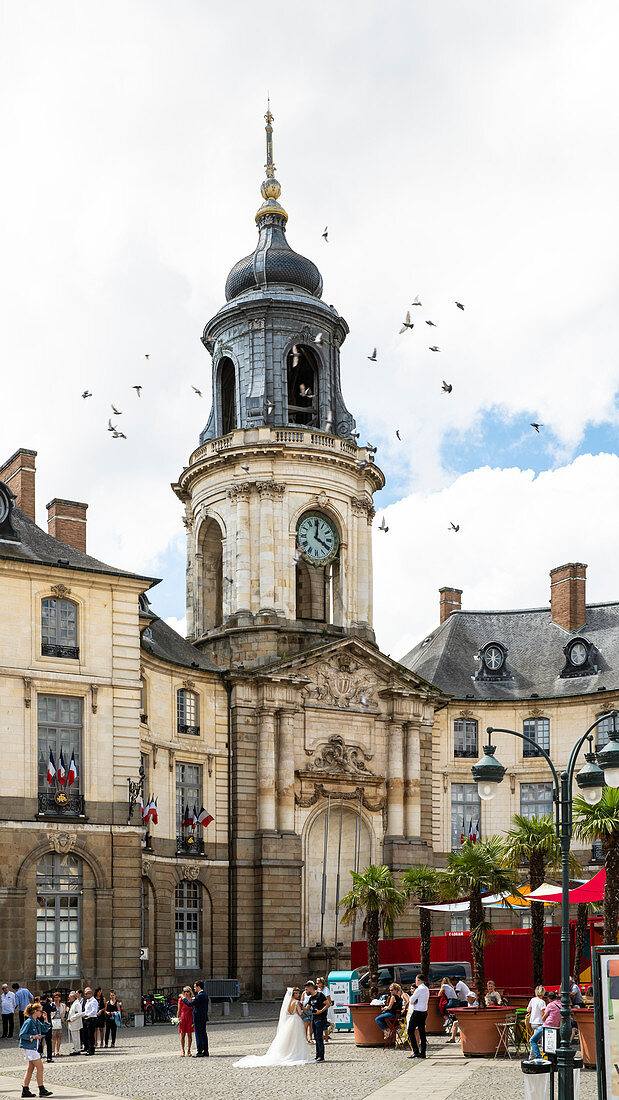 Brautpaar auf dem belebten Rathausplatz mit Uhrenturm, Place de la Mairie, Rennes, Departement Ille-et-Vilaine, Bretagne, Frankreich, Europa