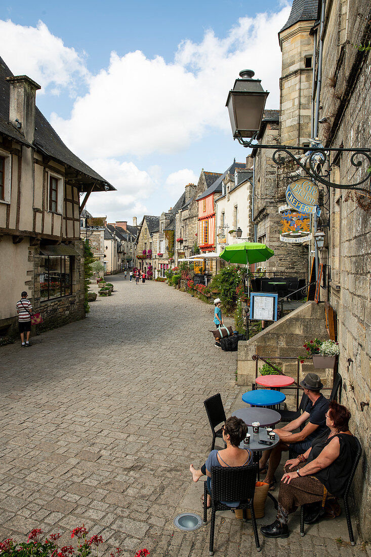 Medieval alley on Place du Puits with people in cafe, Rochefort en Terre, Morbihan department, Brittany, France, Europe
