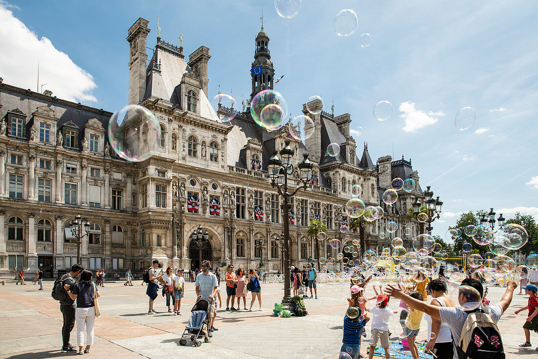 Kinder spielen mit Seifenblasen vor dem Hotel De Ville, dem größten Rathaus Europas, Hotel De Ville, Paris, Frankreich, Europa