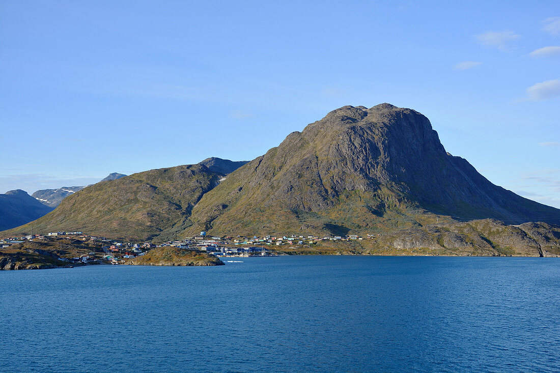Narsaq in South Greenland; View from the water; the place nestles close to the foothills of the mountain Qaqqarsuaq; colorful Houses; small factories; Harbor entrance; surrounded by mountains, rocks, meadows;