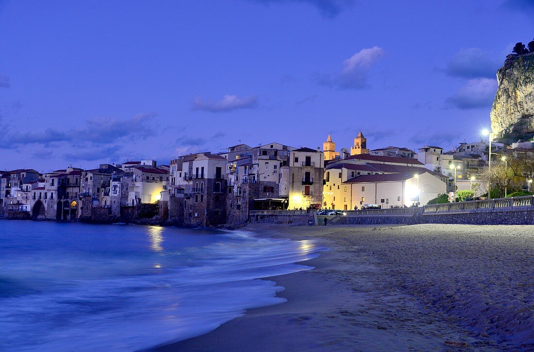 Evening on the beach of Cefalu with its old waterfront houses, north coast, Sicily, Italy