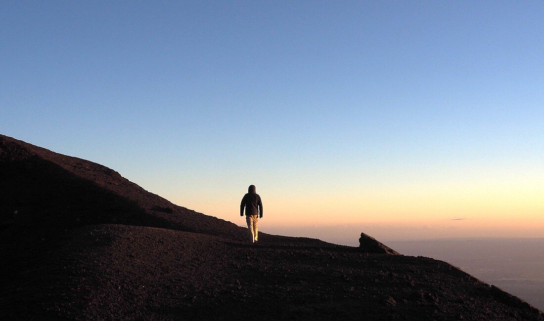 Sunset, man, tourist on Etna volcano, south side, east coast, Sicily, Italy