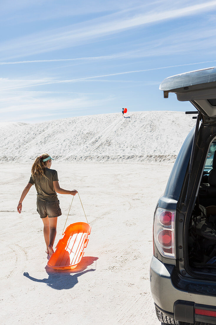 teenage girl with sled, White Sands Nat'l Monument, NM