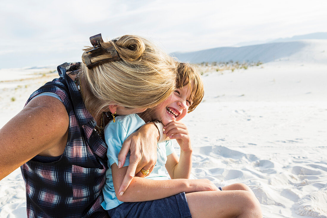 Mutter und ihr sechsjähriger Sohn umarmen sich, White-Sands-Nationalpark, New Mexico, Vereinigte Staaten