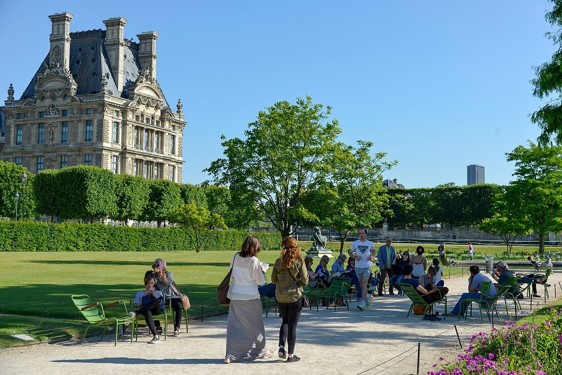 France, Paris, area listed as World Heritage by UNESCO, Garden of the Tuileries, walkers on a path in sand with the Museum dof Louvre in the background