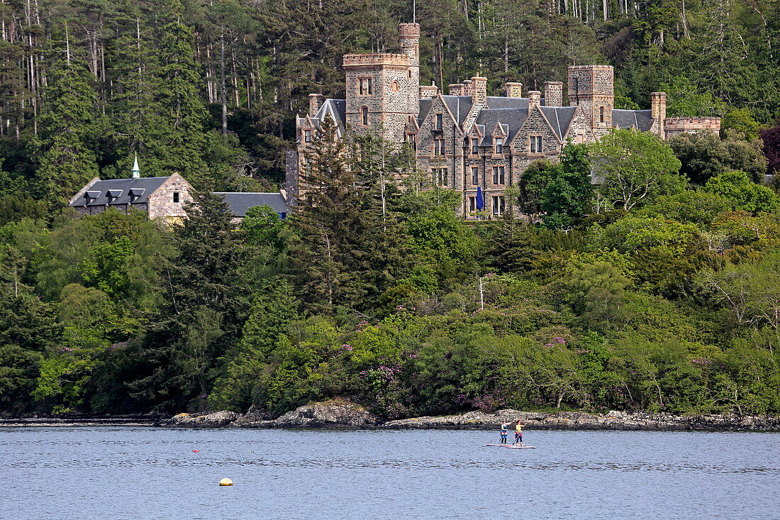 Stand-up paddle boarders in front of Duncraig Castle on Loch Carron, Plockton, Highlands