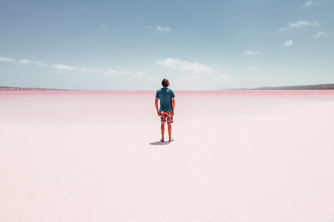Male person stands on Pink Lake in Western Australia, Australia, oceans;