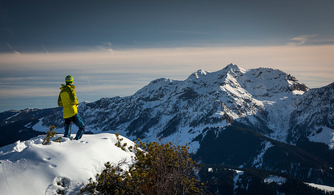Mann an der Buchensteinwand in Fieberbrunn, Wilder Kaiser bei Winter im Sonnenuntergang, Tirol, Österreich