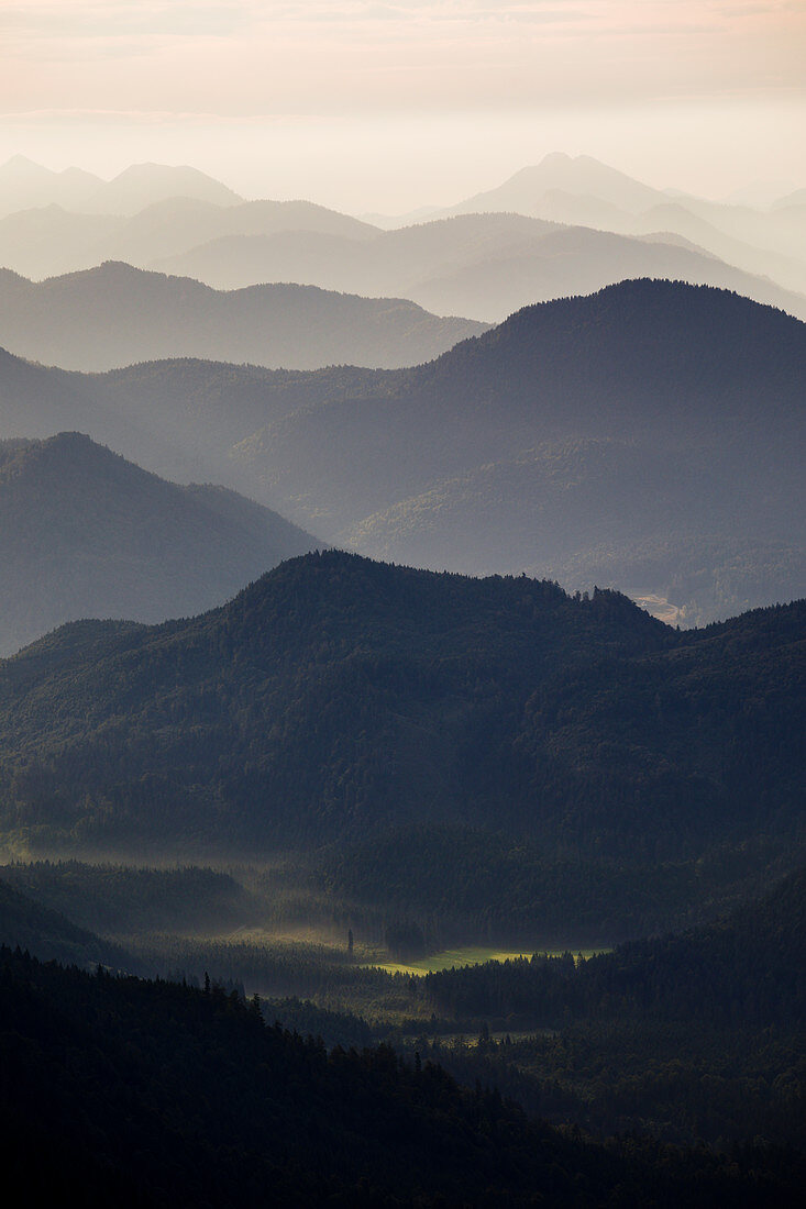 Mountain silhouettes Jachenau am Walchensee with morning mist in sunrise, from Jochberg, Bavarian Prealps