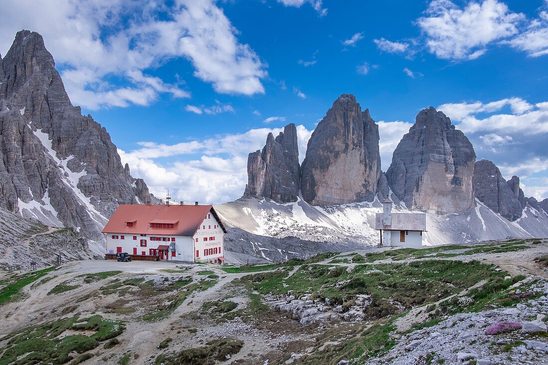 Drei Zinnen hut with a view of Paternkofel and Drei Zinnen summit in the Dolomites by day, South Tyrol