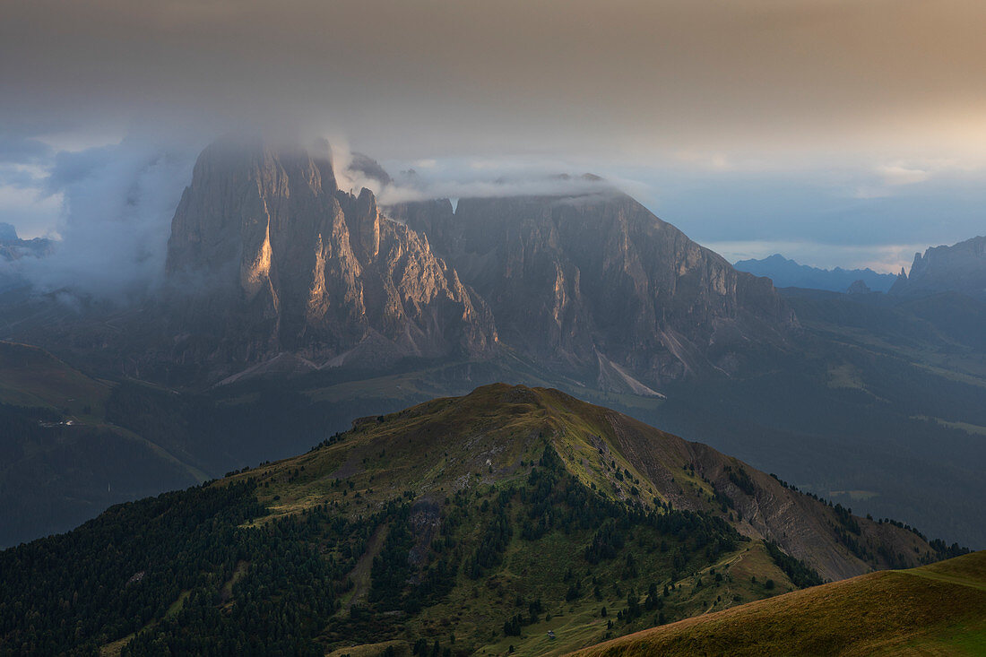 Sassolungo mountains in clouds at sunset from Seceda in the Dolomites, South Tyrol