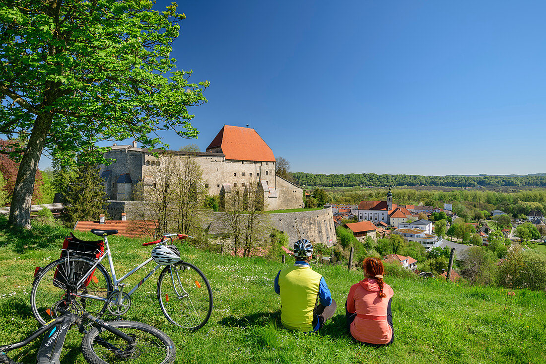 Frau und Mann beim Radfahren machen vor Burg Tittmoning Pause, Tittmoning, Benediktradweg, Oberbayern, Bayern, Deutschland