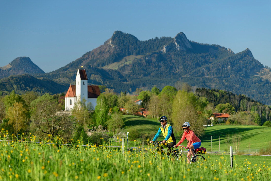 Woman and man cycling, Grainbach and Heuberg in the background, Samerberg, Chiemgau, Chiemgau Alps, Upper Bavaria, Bavaria, Germany